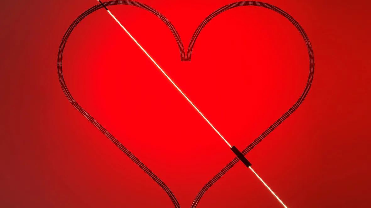 Lampada da parete dove i binari di un trenino elettrico disegnano un cuore e conducono la corrente Rail di Davide Groppi